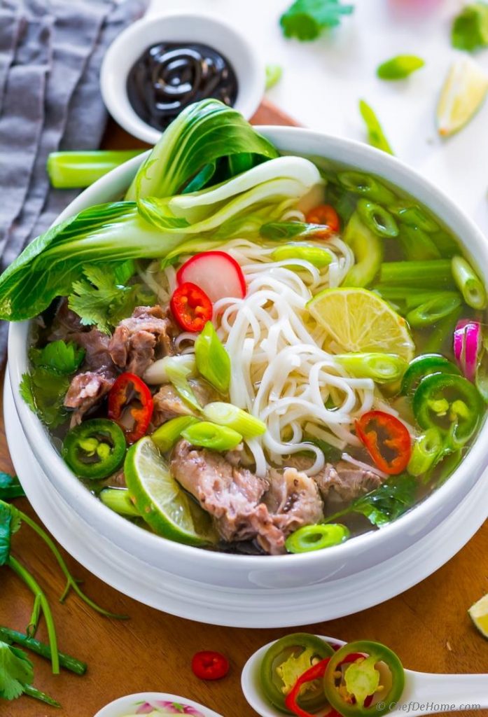 a bowl of noodle with beef, mixed vegetable named pho